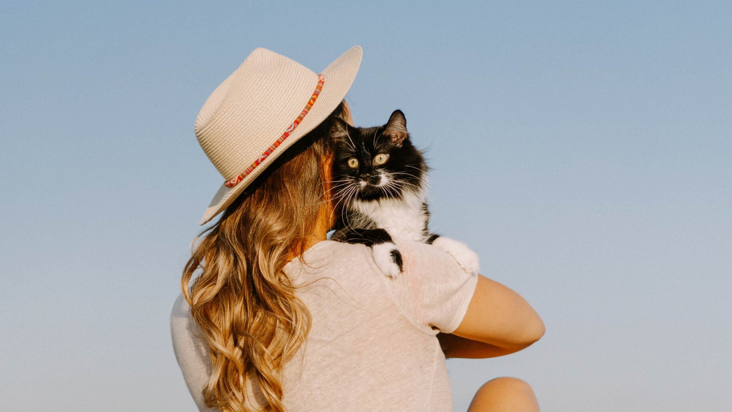Dona com seu gato na praia